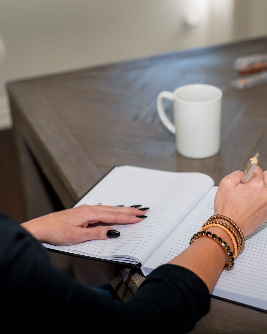 Close view of hands writing in a notebook